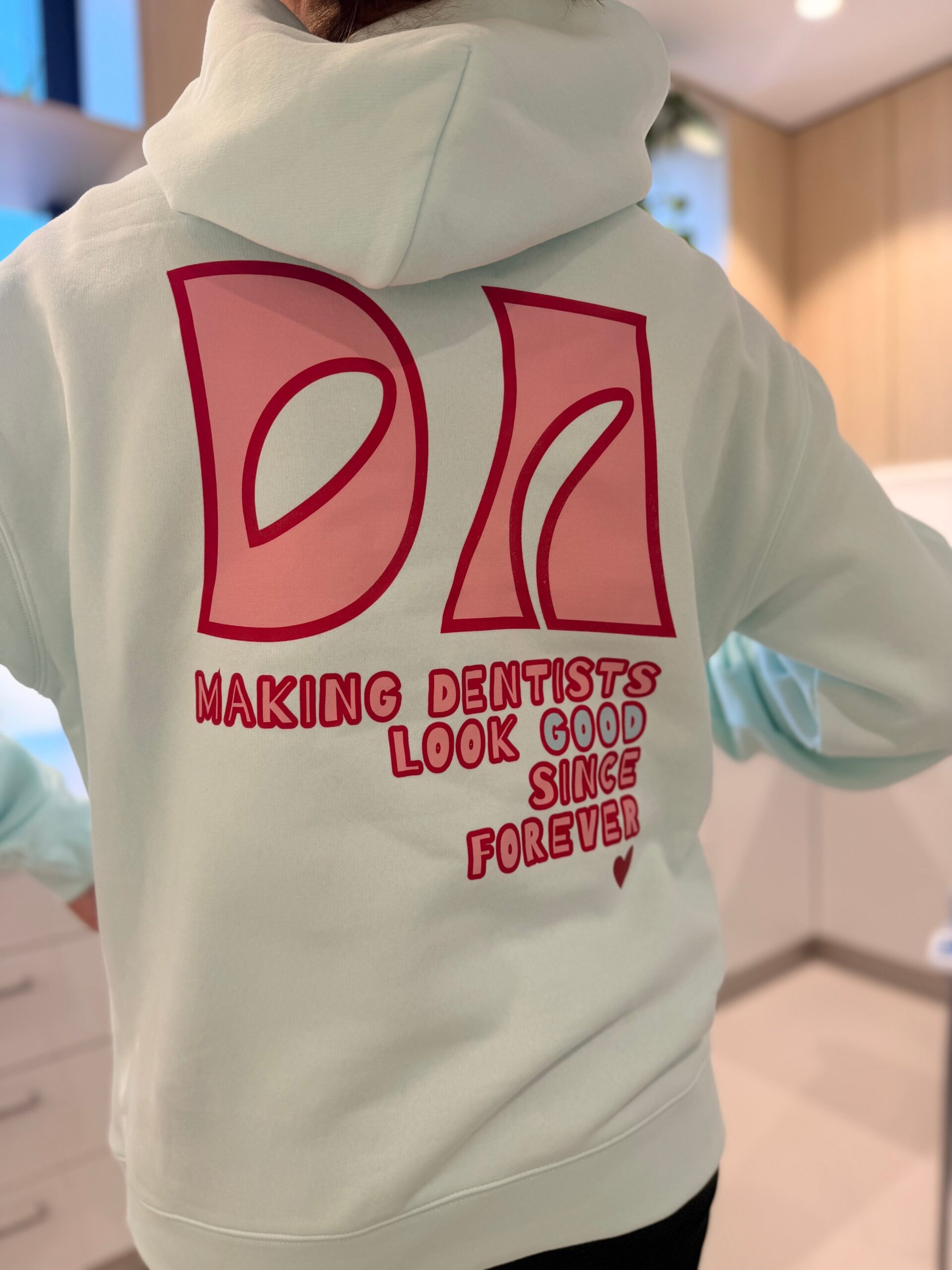 Dental assistant hoodie in seafoam, back print reading Making Dentists Look Good Since Forever